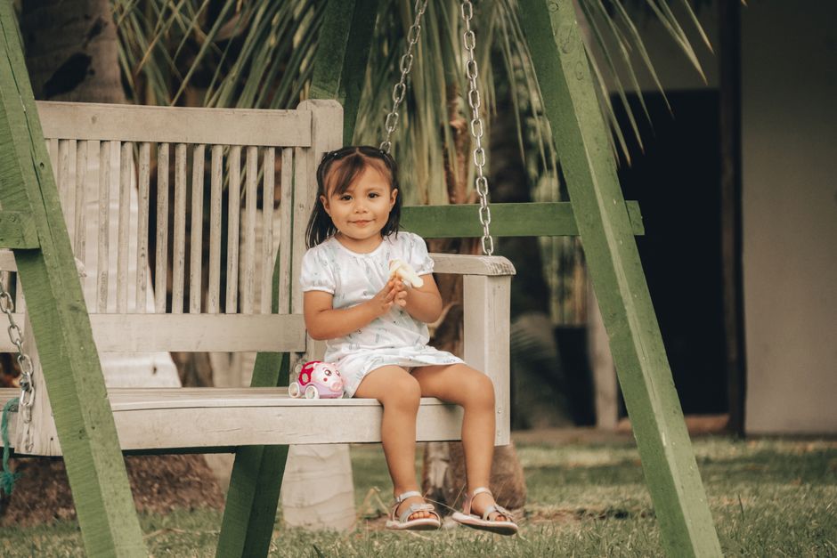 Bé chơi xích đu ở công viên gần nhà