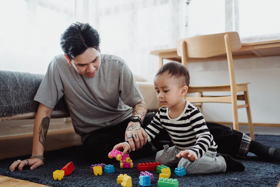 Bố và con chơi xếp hình trong phòng khách