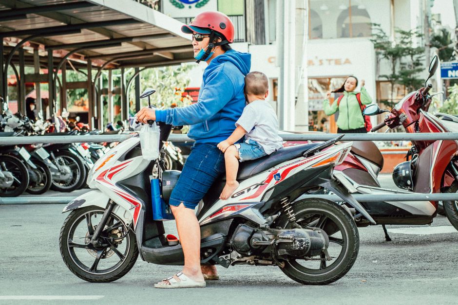 Bố và con đi xe máy trên phố