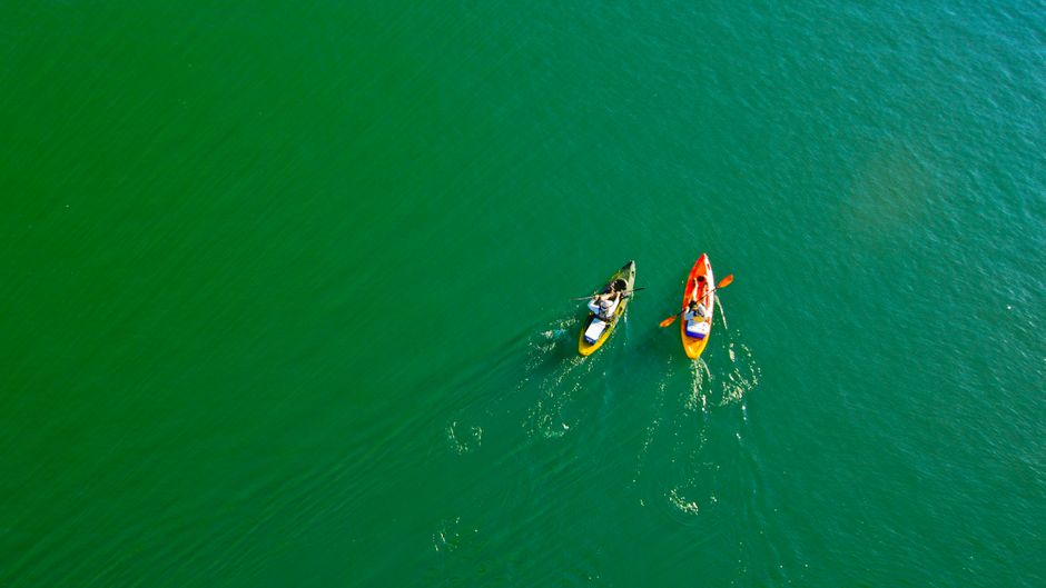 Các bạn nhỏ chèo thuyền kayak trên hồ